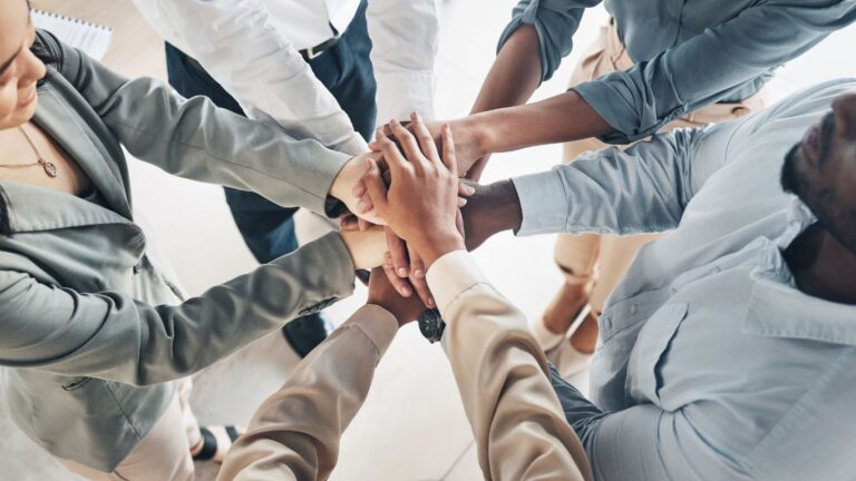 Teamwork with hands joined in circle.