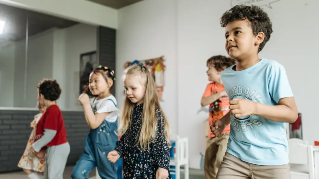 Children joyfully dancing in a classroom setting.