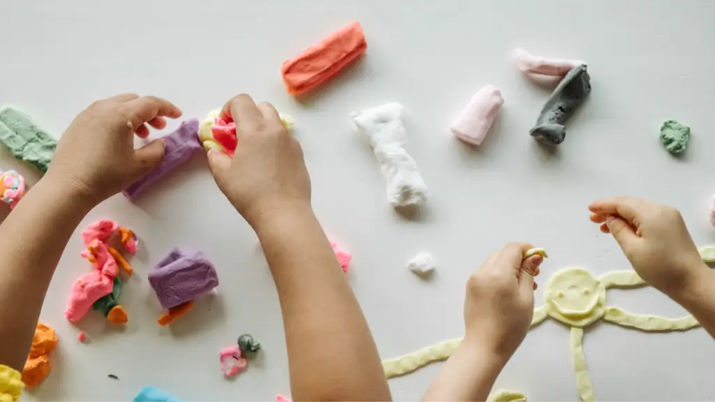Children's hands playing with colorful clay.