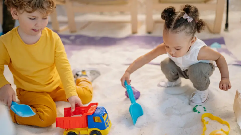 Children playing with toys in the sand.
